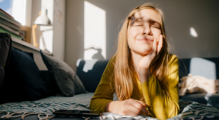 Girl lying on couch at home in sunshine