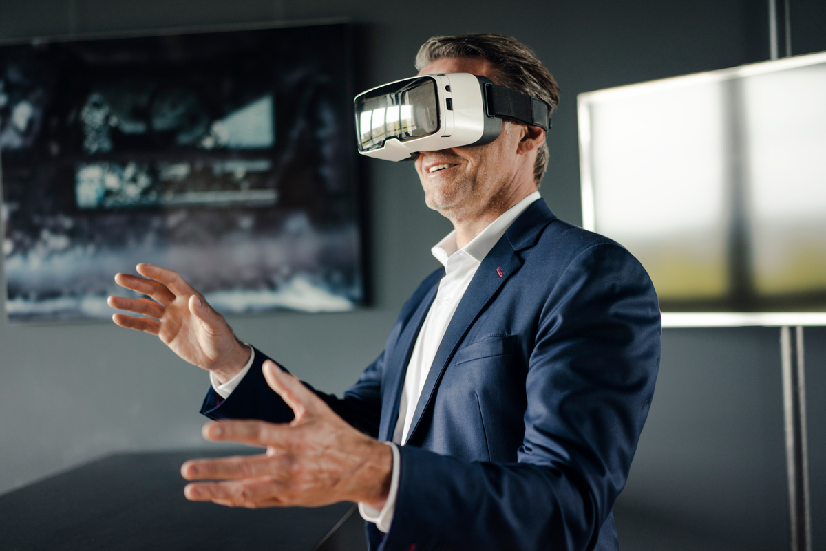 Mature businessman wearing VR glasses in office