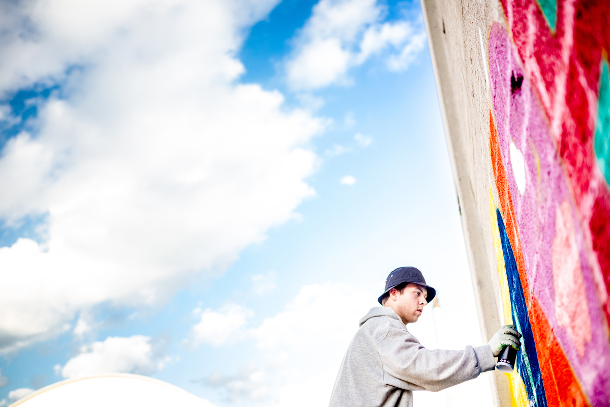 Late Teen Graffiti Artist Drawing Graffiti on Wall