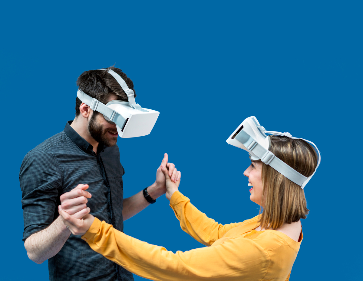 Happy couple using virtual reality glasses against blue screen