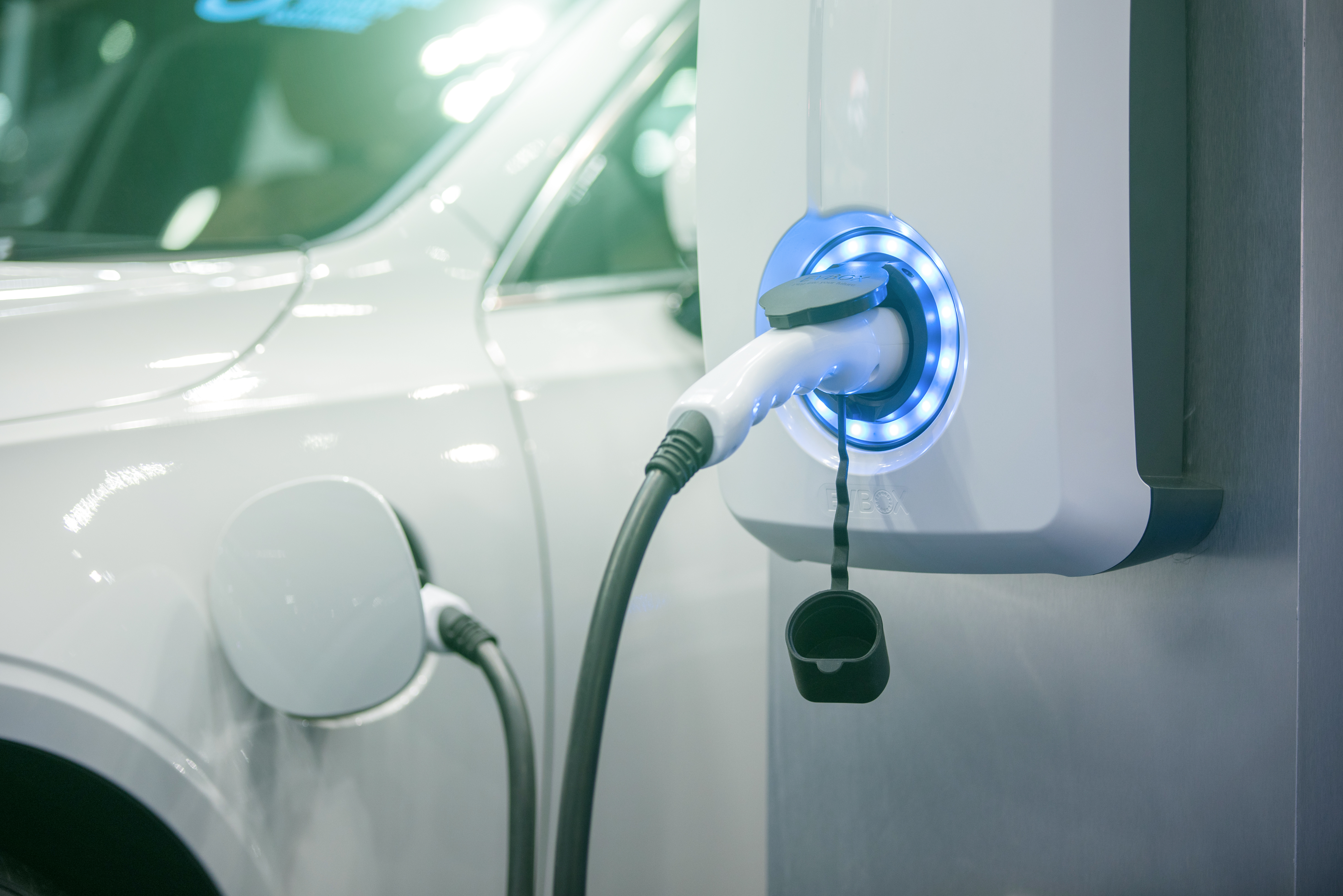 Power supply for electric car charging. Electric car charging station. Close up of the power supply plugged into an electric car being charged.