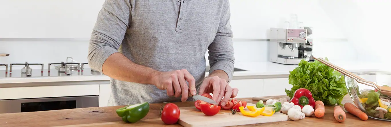 hombre cortando verduras en la cocina